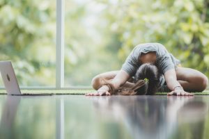 young beautiful caucasian girl doing yoga in the morning, stretching her body after wake up